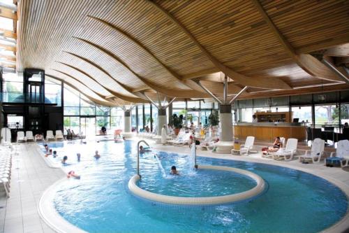 a large swimming pool with people in a building at Le Beau Site Grand Hotel - lovely heritage cocoon Aix-les-Bains central park in Aix-les-Bains