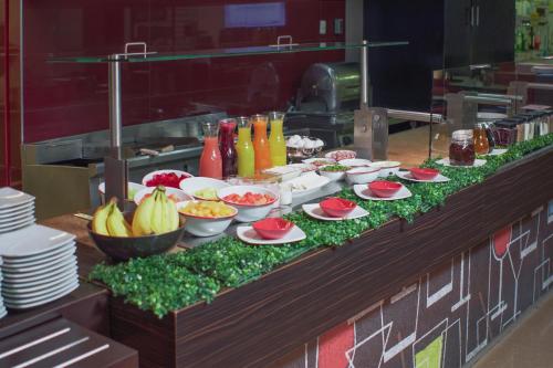 a buffet line with plates of food and fruits at Ibis Hermosillo in Hermosillo
