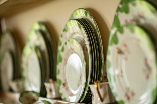 a row of green and white plates on a shelf at Higher Farm in Malpas