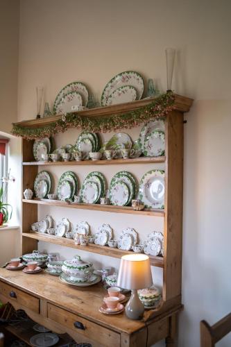 a shelf with plates and dishes on it at Higher Farm in Malpas