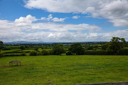 a park with a bench in a green field at Higher Farm in Malpas