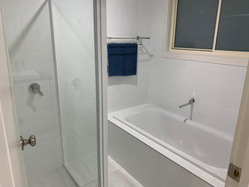 bagno bianco con doccia e vasca di Beachside & Jetty View Apartment 1 - Admirals Apartment a Streaky Bay