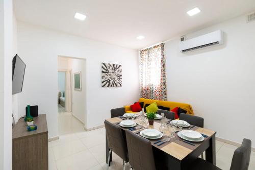 Un comedor y una sala de estar con mesa y sillas. en Brand new apartment in Sliema 2 min by the sea, en Sliema