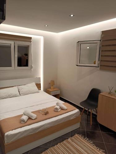 a bedroom with a bed with a desk and a chair at ALEXANDER APARTMENT'S in Kallithea Halkidikis