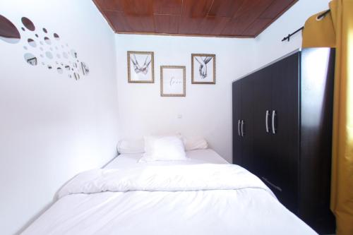 a bedroom with two beds and a black cabinet at Studio meublé Carrefour Bastos en face du Black and White in Yaoundé
