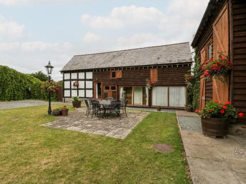 a house with a table and chairs in the yard at Stable End in Pembridge