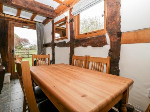 a dining room with a wooden table and chairs at Stable End in Pembridge