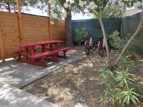un tavolo da picnic e due biciclette parcheggiate accanto a una recinzione di Hera Bnb a Metaponto