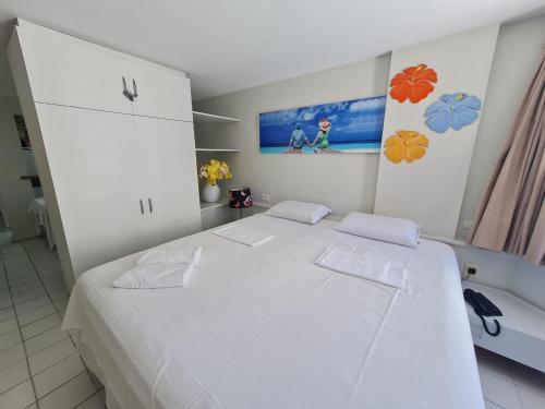 a bedroom with a large white bed with two pillows at Lindo Estúdio vista mar com cama king in João Pessoa
