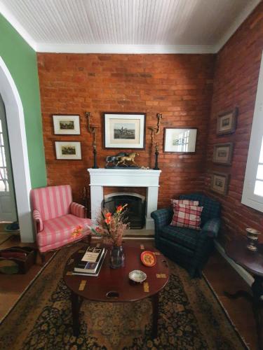a living room with two chairs and a fireplace at Casa Villa Constanza in Itaipava