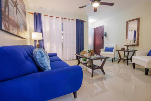 a living room with a blue couch and a table at DOLCE VILLAS AT HARMONY 2 in Santiago de los Caballeros