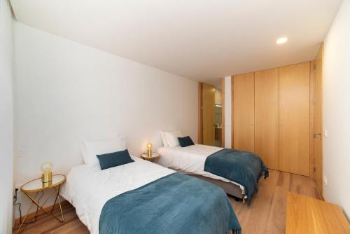 a bedroom with two beds and a table at Ria Sal apartments in Aveiro