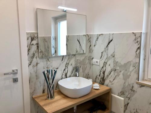 Un baño con un lavabo blanco y un espejo. en Il Melograno chic&nature, en Santa Maria La Carità