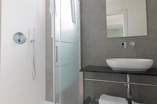 a bathroom with a sink and a glass shower at Hotel President in Lido di Jesolo