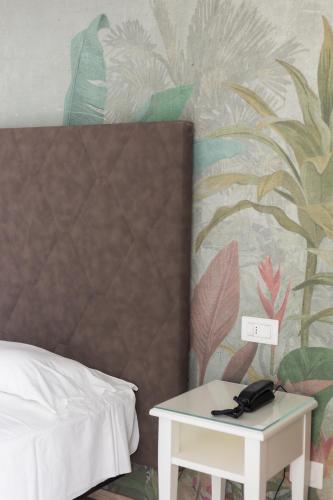 a bedroom with a bed and a table with a phone at Hotel President in Lido di Jesolo