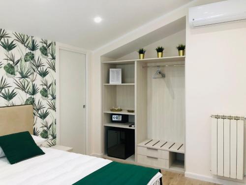 ein Schlafzimmer mit einem Bett und einer Wand mit Pflanzen in der Unterkunft Il Melograno chic&nature in Santa Maria La Carità