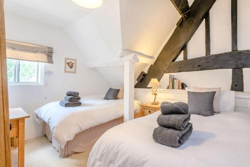 two twin beds in a room with beams at Fern Hall Cottage in Upper Welson