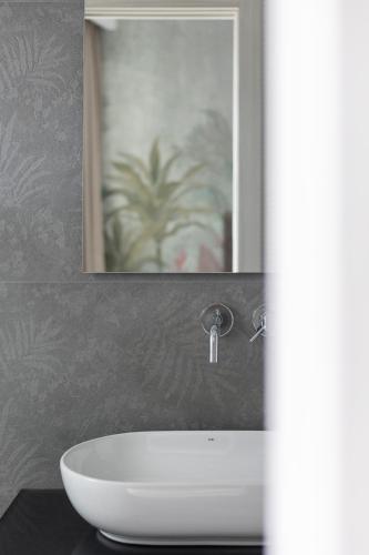 a white sink in a bathroom with a mirror at Hotel President in Lido di Jesolo