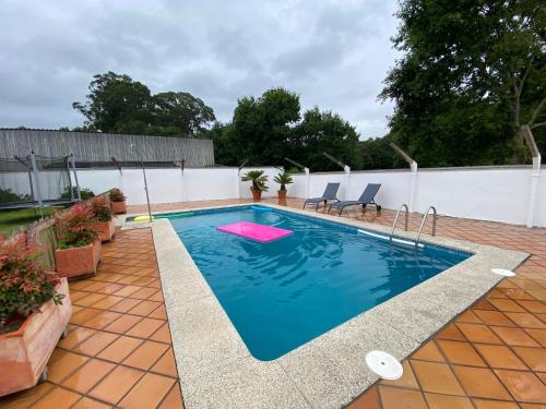 a swimming pool on a patio with two chairs in the water at Villa Poexa in Rosal