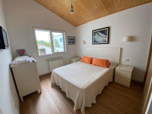 a bedroom with a bed with orange pillows on it at Villa Poexa in Rosal