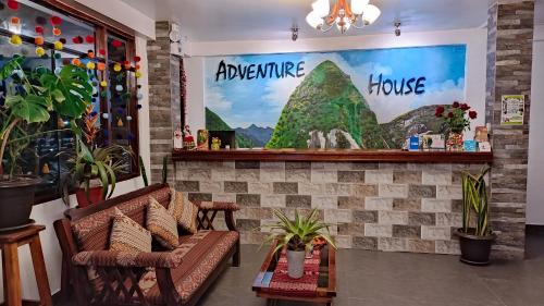 a room with a couch and a picture of a house at Hotel Machupicchu Adventure in Machu Picchu