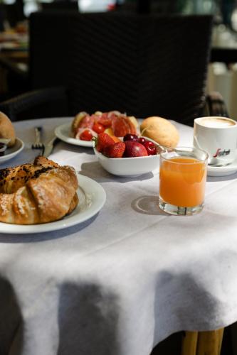 a table with plates of pastries and a glass of orange juice at Hotel President in Lido di Jesolo