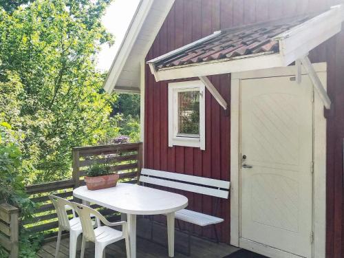 eine Terrasse mit einem weißen Tisch und einer weißen Tür in der Unterkunft 5 person holiday home in FLODA in Floda