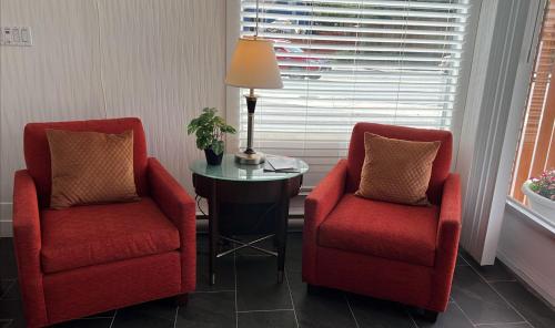 two red chairs and a table in a room at The Spot in Nanaimo