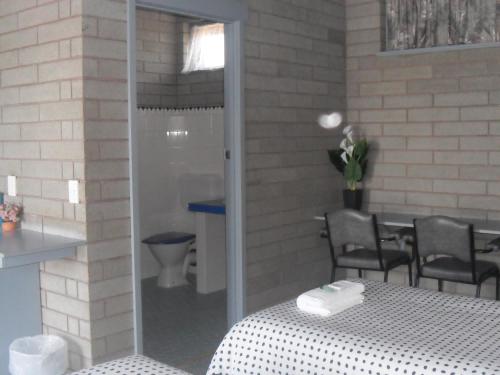 a room with a table and chairs and a toilet at Motel Dimboola in Dimboola