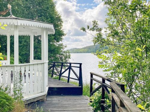 6 person holiday home in VERUM في Överum: رصيف خشبي مع شرفة بجانب البحيرة