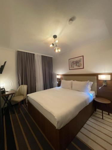 a hotel room with a large bed and a desk at Hotel Casa Andalucia in Hallbergmoos