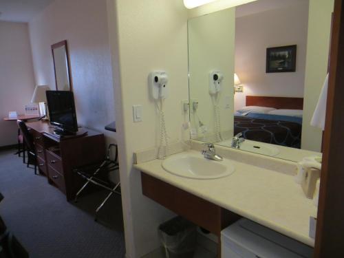 a bathroom with a sink and a phone in a hotel room at Super 8 by Wyndham Edmonton/West in Edmonton