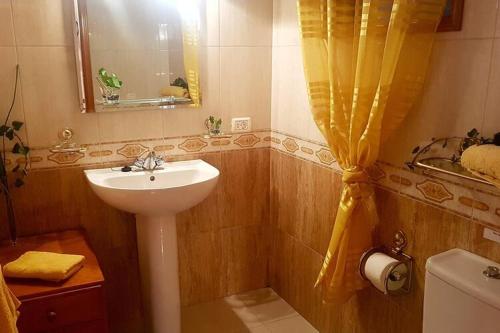 a bathroom with a sink and a yellow shower curtain at Holiday resort Grandiosa El Paso in El Paso
