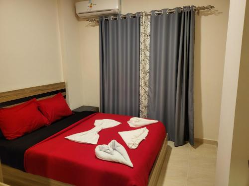 a bedroom with a red bed with white shoes on it at Luxury Aqua Tropical Resort Next To Al Gouna 4 0 1 in Hurghada