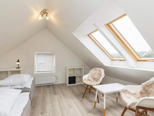 a attic room with skylights and a bed and chairs at Holiday home Hals CXXI in Hals