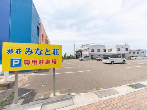ein Parkplatz mit gelbem Schild auf einem Parkplatz in der Unterkunft Tabist Ryosou Minatosou Joetsu in Naoetsu