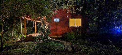 una casa roja con una ventana a un lado. en OMA CHILL HOUSE IGUAZU en Puerto Iguazú