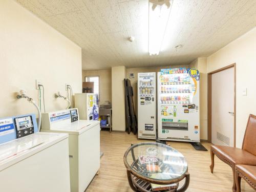 a room with a refrigerator and a glass table at Ryosou Minatosou Joetsu in Naoetsu