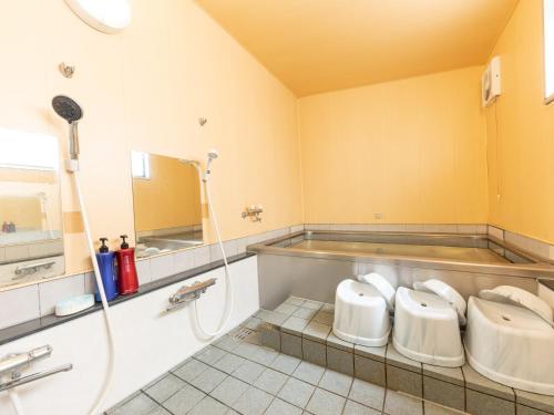 a bathroom with three sinks and a shower at Ryosou Minatosou Joetsu in Naoetsu