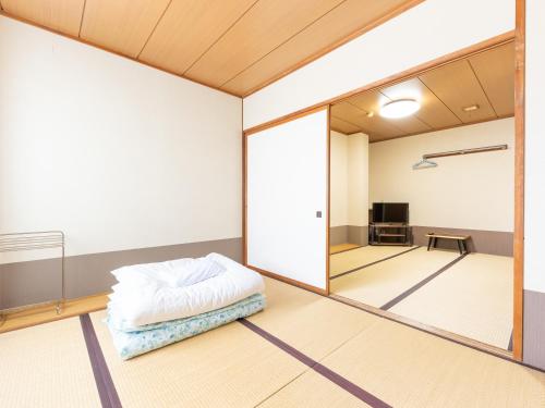 a room with a bed and a large mirror at Ryosou Minatosou Joetsu in Naoetsu