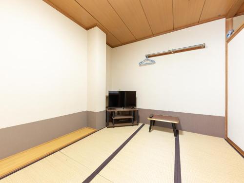 an empty room with a tv and a bench at Ryosou Minatosou Joetsu in Naoetsu