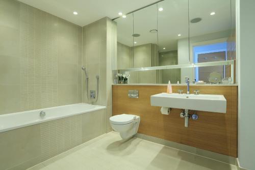 a bathroom with a sink and a toilet and a bath tub at 9 Dart Marina in Dartmouth