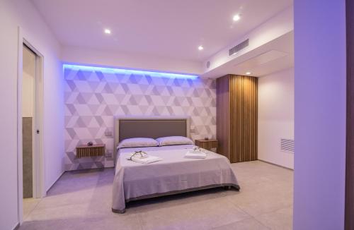 een slaapkamer met een bed en een paarse muur bij SG Suite & Spa Amalfi Coast in Vietri