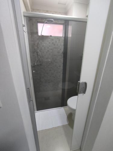 uma casa de banho com um WC e uma porta de duche em vidro. em Iguaçu Hospedagem em Foz do Iguaçu