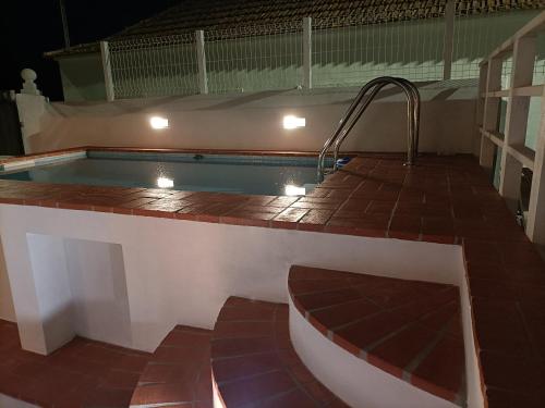 una piscina con bañera de hidromasaje en la parte superior de un edificio en Casa dos Pedro´s en Vila Nova