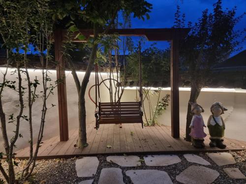 two figurines standing next to a swing with a bench at Yeonriji in Gyeongju