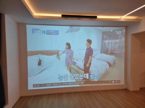 a projection screen in a room with two beds at Yeonriji in Gyeongju