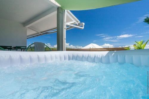 piscina con ombrellone e acqua di Appartement B François a Le François