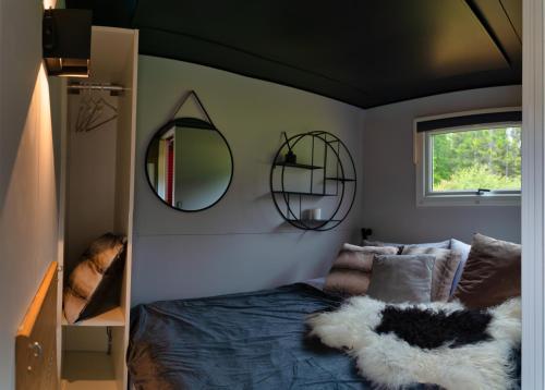 a bedroom with a bed with two mirrors on the wall at Golden Circle Truck Hotel in Selfoss