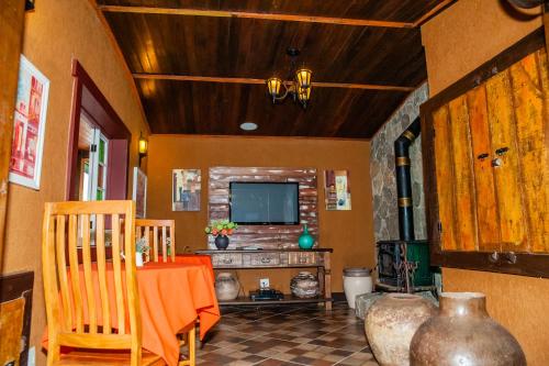 a living room with a television and a table and chairs at Tiradentes Village in Tiradentes